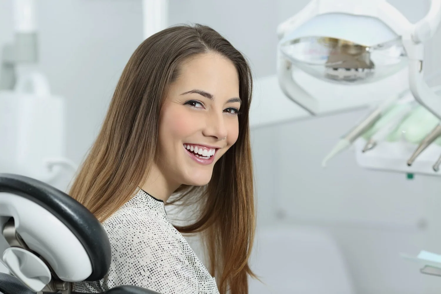 A smiling patient in a dental chair